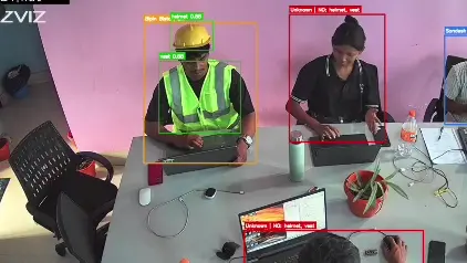 Live CCTV view with boxes around each worker, labelled with their name and any missing PPE such as helmet or vest